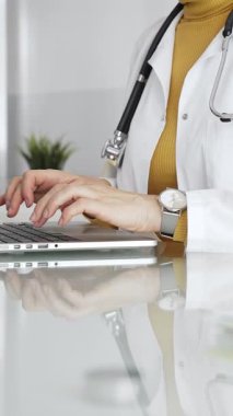 Dizüstü bilgisayarda çalışan kadın doktor, hasta verilerini yöneten, klinikte reçete yazan. Tıp, sağlık ve bilim kavramı.