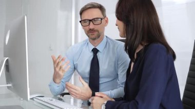 Profesyonel iş arkadaşları masaüstü bilgisayarında işbirliği yapıyor ve iletişim kuruyor, bilgiyi analiz ediyor, görüşleri paylaşıyor ve modern ofis ortamında stratejiler geliştiriyor.