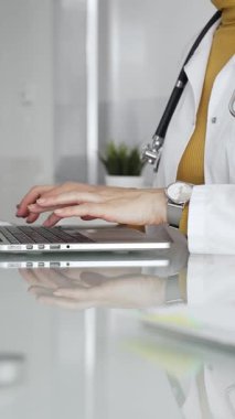 Dizüstü bilgisayarda çalışan kadın doktor, hasta verilerini yöneten, klinikte reçete yazan. Tıp, sağlık ve bilim kavramı.