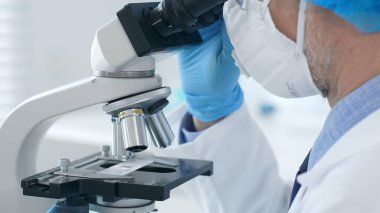 Mikroskop ve bilim adamları laboratuvar setine yakın çekim yapan mavi eldivenleri teslim ediyorlar. Tıp, bilim konsepti.