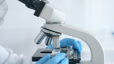 Mikroskobu kapat ve bilim adamları laboratuarda ayarlayan mavi eldivenleri teslim et. Tıp, bilim konsepti.