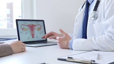 Doktor hastayla dijital test sonuçlarını gözden geçiriyor, klinik konsültasyon sırasında laptopta sağlık bulgularını tartışıyor. İlaç ve sağlık hizmetleri kavramı