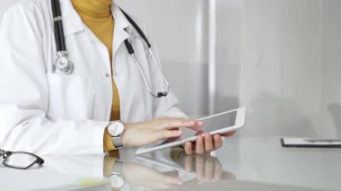 Klinikte dijital tablet kullanan laboratuvar önlüğü ve steteskop giyen bir doktor. Modern tıp ve tele sağlık konsepti. Tıp, sağlık ve bilim konsepti