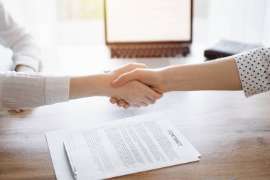 İş adamları kontrat kağıtlarının üzerinde el sıkışıyor. Tahta masaya yeni imzalanmış. Kapatın. Toplantıdaki avukatlar. Takım çalışması, ortaklık, başarı kavramı.