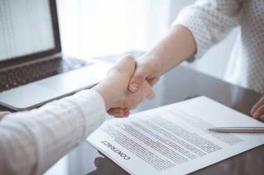 İş adamları sözleşme kağıtlarının üzerinde el sıkışıyorlar. Gri masaya yeni imzaladılar. Kapatın. Avukatlar ya da girişimciler toplantıda. Takım çalışması, ortaklık, başarı kavramı.