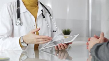 Doktor hastayla ilgileniyor, muayene sırasında sağlık verilerini tablet bilgisayarda gösteriyor. Çevrimiçi tıbbi danışmanlık hizmeti veren bir sağlık uzmanı. Tıp, sağlık ve bilim konsepti
