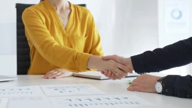 Başarılı bir toplantının ardından iş ortaklarının el sıkışması, şık, modern ofis ortamında bir iş anlaşmasının veya sözleşmenin sağlamlaştırılması