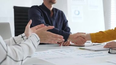 Başarılı bir toplantının ardından iş ortaklarının el sıkışması, şık, modern ofis ortamında bir iş anlaşmasının veya sözleşmenin sağlamlaştırılması.