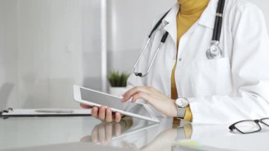 Klinikte dijital tablet kullanan laboratuvar önlüğü ve steteskop giyen bir doktor. Modern tıp ve tele sağlık konsepti. Tıp, sağlık ve bilim konsepti