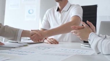 İş adamı başarılı bir toplantının ardından bir iş kadınıyla tokalaşıyor, şık ve modern bir ofis ortamında bir iş anlaşmasını sağlamlaştırıyor. El sıkışma kavramı.
