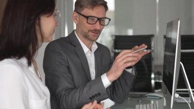 İş arkadaşları bilgisayar, kadın ve erkek birlikte çalışıyor, fikirleri paylaşıyor ve başarılı bir mesleki tartışma ve takım çalışması sırasında gülümsüyor.