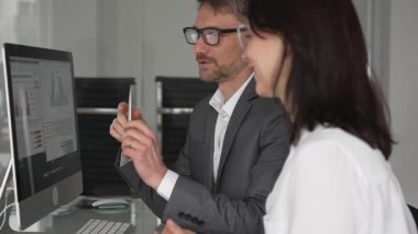 İş arkadaşları bilgisayar, kadın ve erkek birlikte çalışıyor, fikirleri paylaşıyor ve başarılı bir mesleki tartışma ve takım çalışması sırasında gülümsüyor.