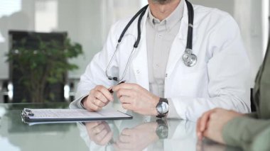 Doktorlar, bir sağlık kliniğinde ya da hastane ofisinde bir hastaya danışmanlık yaparken panoya notlar yazarlar. Tıp, sağlık ve bilim konsepti