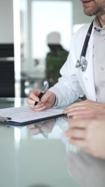 Doktorlar, bir sağlık kliniğinde ya da hastane ofisinde bir hastaya danışmanlık yaparken panoya notlar yazarlar. Tıp, sağlık ve bilim konsepti