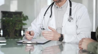 Doktorlar, bir sağlık kliniğinde ya da hastane ofisinde bir hastaya danışmanlık yaparken panoya notlar yazarlar. Tıp, sağlık ve bilim konsepti