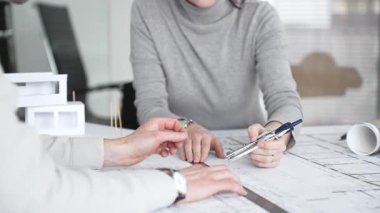 Mimarlar proje planları üzerinde işbirliği yapıyor, mimari tasarımları tartışıyor, inşaat planları geliştiriyor, ofis masasında kavramsal bir model ev yaratıyor, kapatıyorlar.