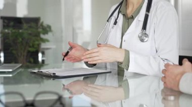 Doktor panoya yazı yazıyor, tıbbi bir randevu sırasında bir hastayla sağlık hakkında konuşuyor, profesyonel bakımı destekliyor. Tıp, sağlık ve bilim konsepti