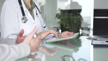 Doktor kadın tablet üzerinde çalışıyor, tıbbi muayenede hasta bilgilerini giriyor. Tıp, sağlık ve bilim konsepti.