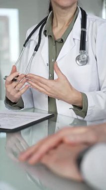 Doktor panoya yazı yazıyor, tıbbi bir randevu sırasında bir hastayla sağlık hakkında konuşuyor, profesyonel bakımı destekliyor. Tıp, sağlık ve bilim konsepti