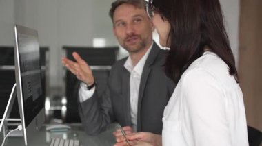 İş arkadaşları bilgisayar, kadın ve erkek birlikte çalışıyor, fikirleri paylaşıyor ve başarılı bir mesleki tartışma ve takım çalışması sırasında gülümsüyor.