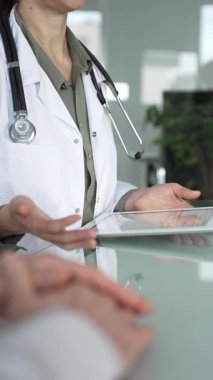 Doktor kadın tablet üzerinde çalışıyor, tıbbi muayenede hasta bilgilerini giriyor. Tıp, sağlık ve bilim konsepti.