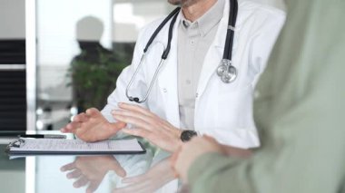 Doktorlar, bir sağlık kliniğinde ya da hastane ofisinde bir hastaya danışmanlık yaparken panoya notlar yazarlar. Tıp, sağlık ve bilim konsepti