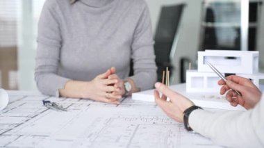 Mimarlar proje planları üzerinde işbirliği yapıyor, mimari tasarımları tartışıyor, inşaat planları geliştiriyor, ofis masasında kavramsal bir model ev yaratıyor, kapatıyorlar.