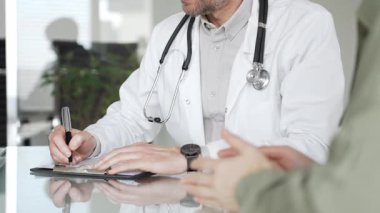 Doktorlar, bir sağlık kliniğinde ya da hastane ofisinde bir hastaya danışmanlık yaparken panoya notlar yazarlar. Tıp, sağlık ve bilim konsepti