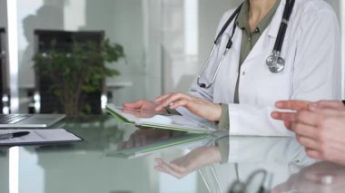 Doktor adam tablet üzerinde çalışıyor, hasta bilgilerini tıbbi muayeneye giriyor. Tıp, sağlık ve bilim konsepti.