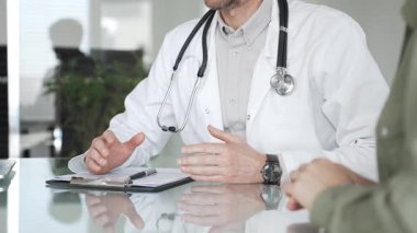 Doktorlar, bir sağlık kliniğinde ya da hastane ofisinde bir hastaya danışmanlık yaparken panoya notlar yazarlar. Tıp, sağlık ve bilim konsepti