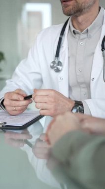 Doktorlar, bir sağlık kliniğinde ya da hastane ofisinde bir hastaya danışmanlık yaparken panoya notlar yazarlar. Tıp, sağlık ve bilim konsepti