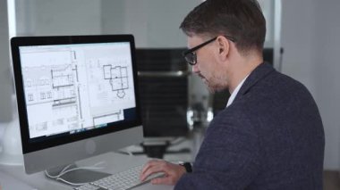 Mühendis, mimari planlama ve gayrimenkul geliştirme üzerine kurulu kaba yazılım üzerine modern bir bina planı tasarlıyor. İş ve mimari kavramı