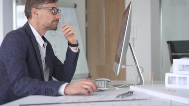 Bina tasarımı ve planlama üzerine odaklanan profesyonel mimar, bir bilgisayar ve fiziksel modelin planlarıyla çalışıyor. İş ve mimari kavramı