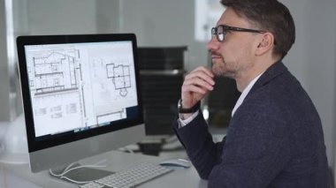 Mimar adam bilgisayarda inşaat planları çiziyor, yeni bina mimarisi tasarlıyor. Mühendislik, geliştirme ve planlama konsepti. İş ve mimari kavramı