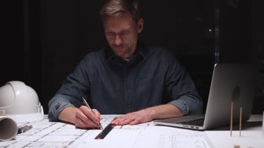 Mimari, profesyonel inşaat planlarını ve mühendislik planlarını geliştiriyor, özenle çiziyor, akşam saatlerinde üretken kalıyor.