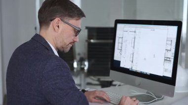 Mühendis, mimari planlama ve gayrimenkul geliştirme üzerine kurulu kaba yazılım üzerine modern bir bina planı tasarlıyor. İş ve mimari kavramı