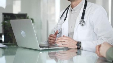 Tıbbi doktor muayene sırasında hastaya test sonuçlarını açıklıyor, dijital sağlık kayıtları ve bilgi için dizüstü bilgisayar kullanıyor. Tıp, sağlık ve bilim konsepti