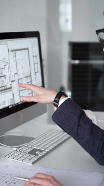 Dijital ve fiziksel yapı planlarını inceleyerek, mimari tasarım projesinde işbirliği yapan mühendislik uzmanları. İş adamları ve mimari konsepti