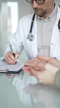 Doktorlar, bir sağlık kliniğinde ya da hastane ofisinde bir hastaya danışmanlık yaparken panoya notlar yazarlar. Tıp, sağlık ve bilim konsepti