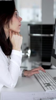 Mimari proje planlayan kadın, planlar ve bilgisayar üzerinde çalışıyor. Modern mimarlık bürosu