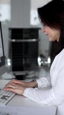 Bir bina projesi planlayan mimar veya mühendis, bir masaüstü bilgisayarındaki planları ve teknik çizimleri gözden geçiriyor. İş ve mimari kavramı