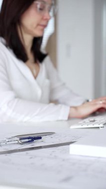 Modern ofis masasında mimari modeller ve inşaat planları tasarlayan, bilgisayar klavyesinde yazan bir mimar. İş ve mimari kavramı