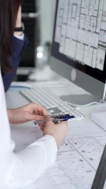 Dijital ve fiziksel yapı planlarını inceleyerek, mimari tasarım projesinde işbirliği yapan mühendislik uzmanları. İş adamları ve mimari konsepti