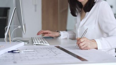 Profesyonel mimar, modern bir ofiste pusula ve cetvelle mimari planlar tasarlıyor. İş ve mimari kavramı