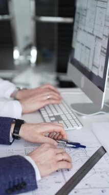 Dijital ve fiziksel yapı planlarını inceleyerek, mimari tasarım projesinde işbirliği yapan mühendislik uzmanları. İş adamları ve mimari konsepti