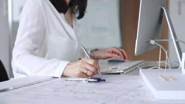 Profesyonel mimar, modern bir ofiste pusula ve cetvelle mimari planlar tasarlıyor. İş ve mimari kavramı