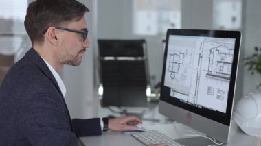 Mühendis, mimari planlama ve gayrimenkul geliştirme üzerine kurulu kaba yazılım üzerine modern bir bina planı tasarlıyor. İş ve mimari kavramı