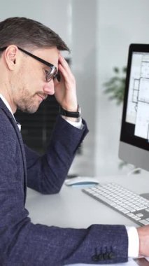 Ofisteki bilgisayar ekranında inşaat planlarını incelerken baş ağrısı ve göz yorgunluğundan muzdarip erkek mimar bunalmış. İş ve mimari kavramı