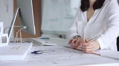 Profesyonel mimar, modern bir ofiste pusula ve cetvelle mimari planlar tasarlıyor. İş ve mimari kavramı