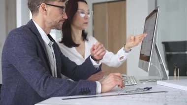 Profesyonel mimar takımı bilgisayar ekranında inşaat projesi planları ve mimari çizimleri tartışıyor. İş ve mimari kavramı